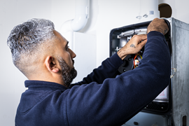 Heating engineer installing a new energy-efficient boiler for a home heating upgrade